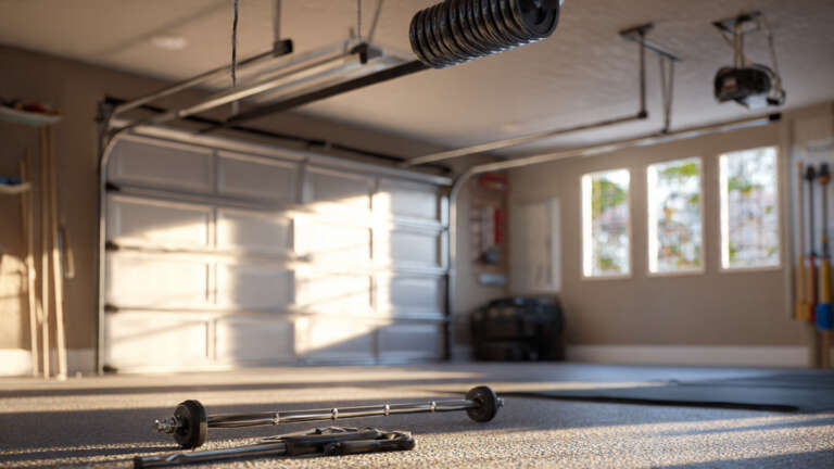 Garage door torsion spring assembly mounted above a closed residential garage door