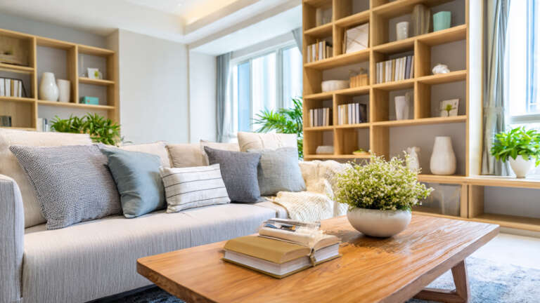 Affordable living room furniture setup with modern sofa, coffee table and bookshelf on a budget