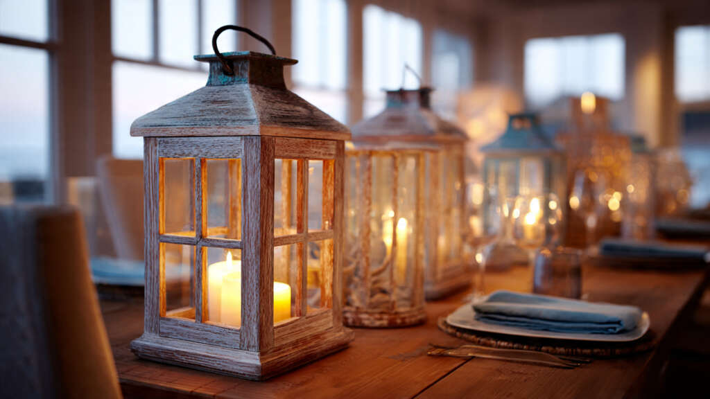 Coastal lanterns providing a soft, warm glow on a beach-inspired dining table.