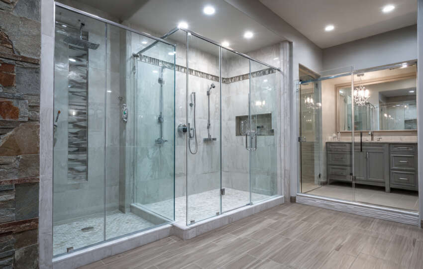 Various shower door styles (frameless, framed, acrylic, and stone) in a modern, stylish bathroom, showcasing design options.