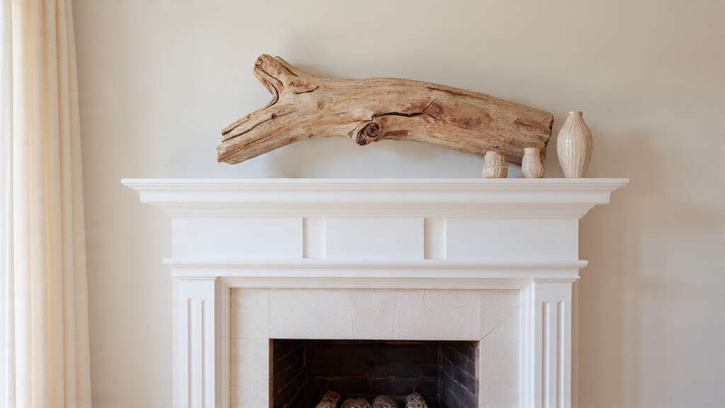 Driftwood arranged as a decorative accent on a coastal-themed mantel.