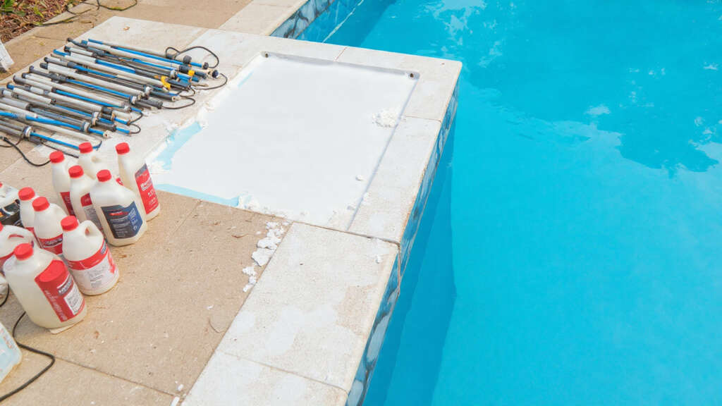 Pool maintenance tools and chemicals arranged for regular upkeep