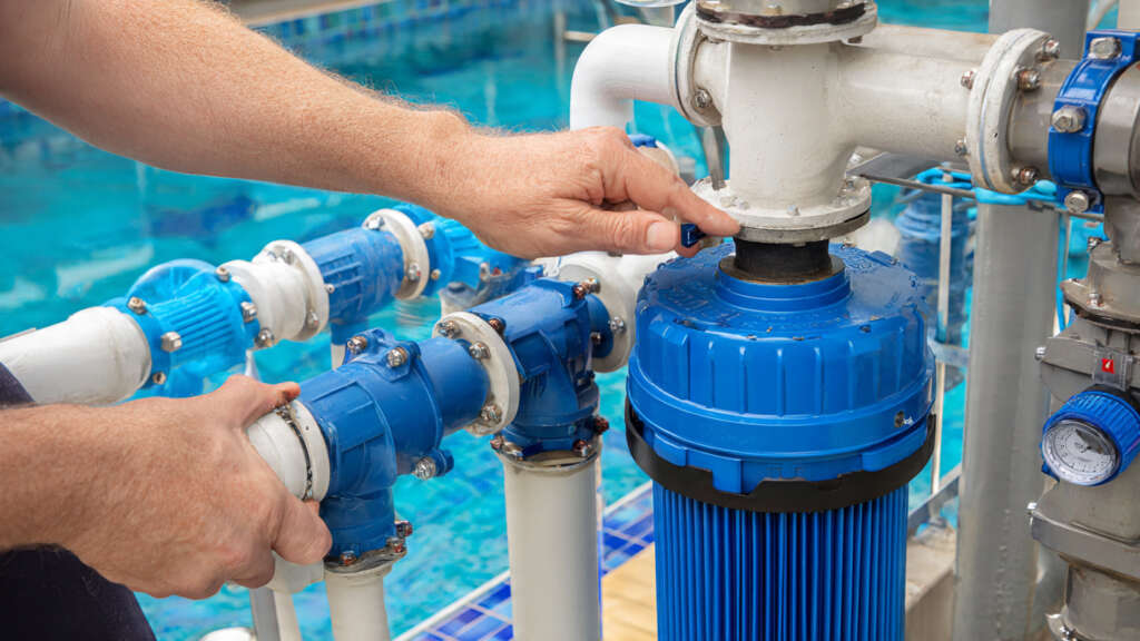 Technician repairing pool pump and filter system