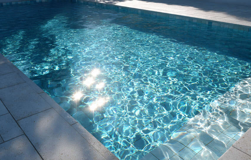 Modern backyard swimming pool with clean blue water reflecting sunlight